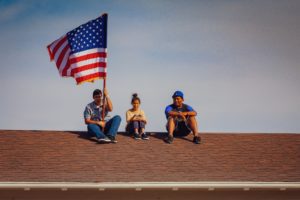 kids on a roof with an american flag